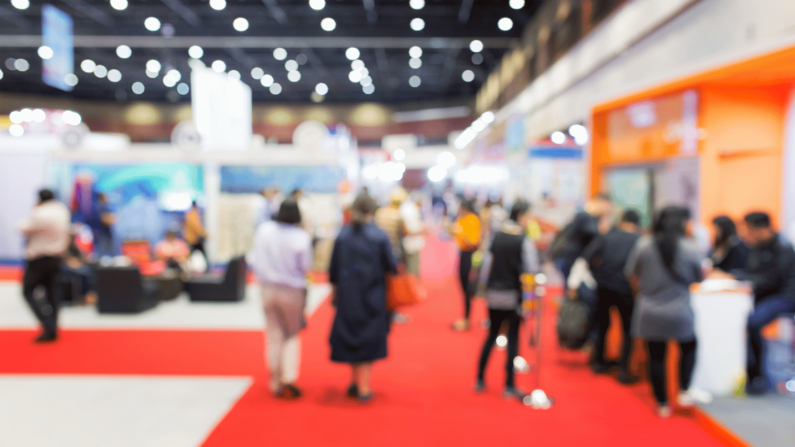 Blured image of people walking on a red carpet at a tradeshow